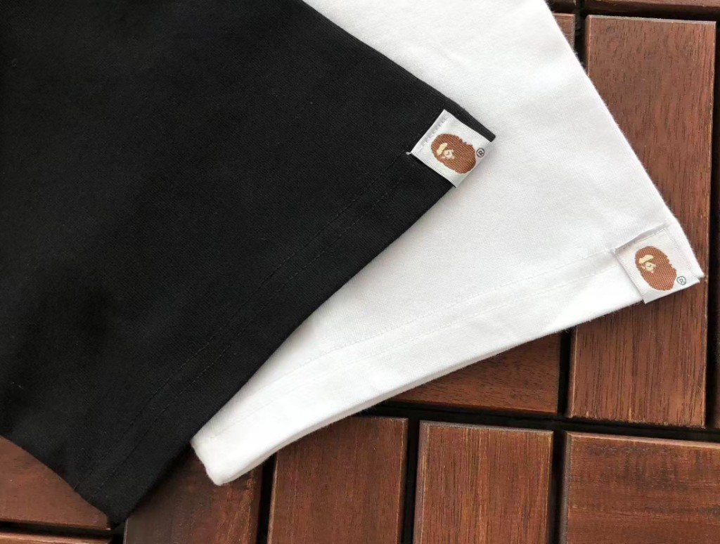 Close-up of woven hem labels on black and white tees
